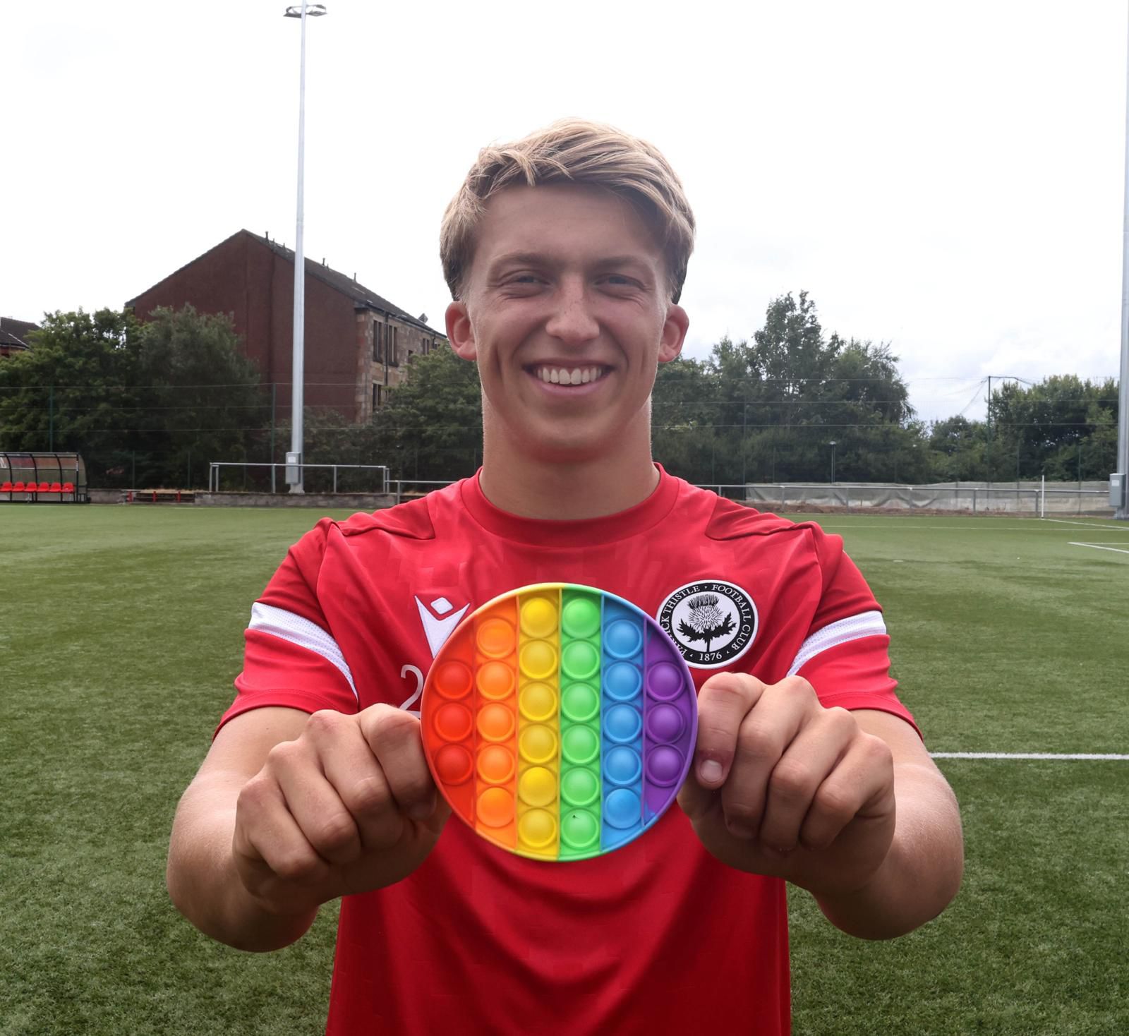 A Partick Thistle player holding a rainbow pop-it fidget toy from the new sensory packs